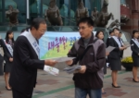신임 이장호 은행장과 직원들이 롯데백화점 정문 앞에서 출근고객들에게 꽃씨를 건네주고 있음
