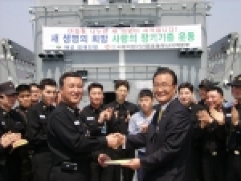 권택헌 청해진 함장이 장병들과 함께‘사랑의 장기기증’ 서약서를 강치영 본부장에게 전달하고 있다.