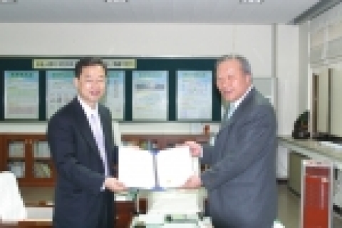 송우근 기획처장(좌측)이 이윤수 정암초등학교장에게 도서기증서를 전달하고 있다.