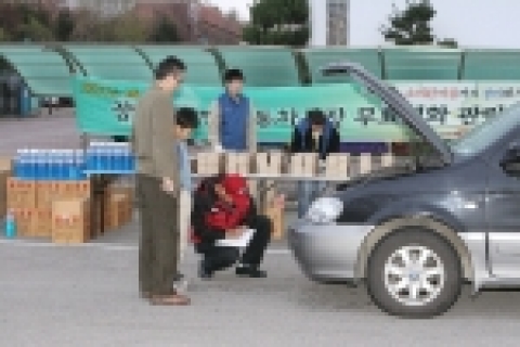 SK네트웍스 스피드메이트의 정비사가 장애인 무료영화관람행사에 참석한 장애인 가족 차량을 무상으로 점검해 주고 있다.