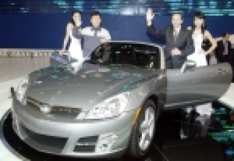 GM DAEWOO 영업담당 릭 라벨(Rick LaBelle)부사장과 이성재 노조위원장이 함께 GM DAEWOO가 부산모터쇼에서 새롭게 선보인 2인승 스포츠 오픈카 &#039;G2X로드스터&#039;를 관람객에게 소개하며 손을 흔들어 보이고있다.