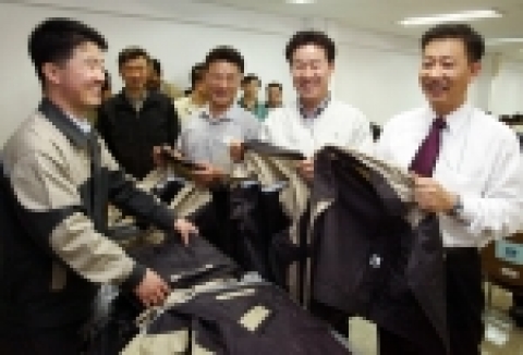 2일 최종 복직된 187명의 직원들이 첫 출근, 재입사 교육을 받기에 앞서 근무복을 수령하며 환하게 웃고 있다.