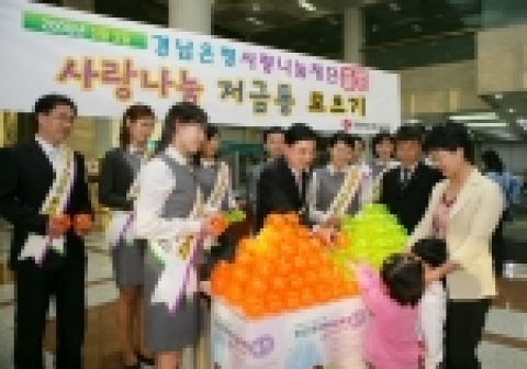 정경득 행장(가운데)이 고객에게 사랑나눔 저금통을 전달하고 있다. 