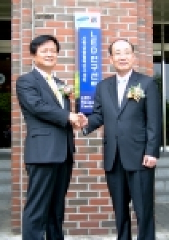 삼성전기 안기훈 전무(왼쪽)와 광주 과학기술원 허성관 원장이 LED연구센터 현판앞에서 악수를 하고 있다. 
