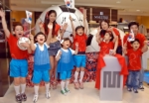 한국 대표팀 응원의 상징인 레드 티셔츠를 입은 마에스트로 첫번째 고객 가족과 어린이들이 대형 축구공 앞에서 파이팅을 외치고 있다.