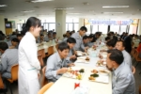 사내식당에서 우럭 매운탕을 먹으며 밝게 웃고 있는 현대중공업 임직원들.