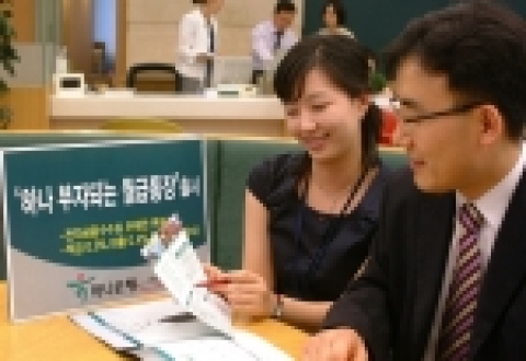 하나은행 직원이 한 셀러리맨 고객에게 '부자되는 월급통장'에 대해 설명하고 있는 모습임 