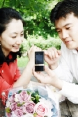 한 청년이 애인의 이름을 새겨넣은 LG전자 초콜릿II 스페셜 에디션을 선물하며 애인에게 프로포즈하고 있다.