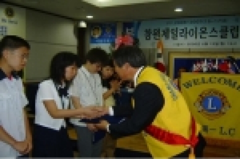 창원시 가음정동에서 가정형편이 어려운 학생에게 장학금을 전달하는 모습