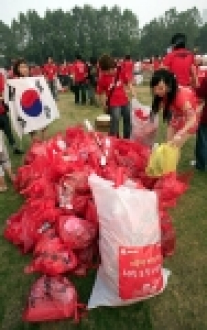 운암김성숙선생기념사업회에서 무료로 배포한 쓰레기 봉투로 쓰레기를 치우고 있다.