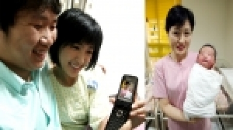 SK텔레콤의 MOBI-DVR 서비스가 제공되고 있는 산부인과 병동에서 산모가 휴대폰을 통해 신생아실의 아기를 살펴보고 있다.