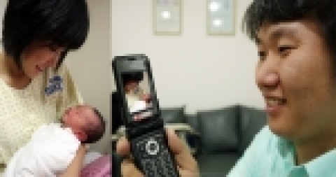 SK텔레콤의 MOBI-DVR 서비스가 제공되고 있는 산부인과 병동에서 산모가 휴대폰을 통해 신생아실의 아기를 살펴보고 있다.