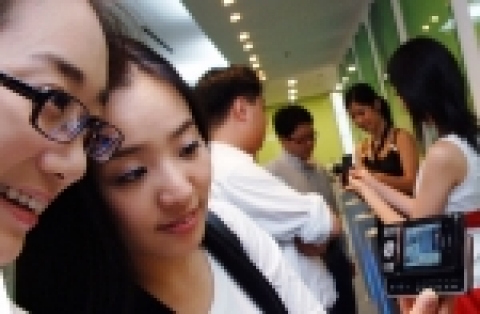 LG전자 전시관을 찾은 관람객들이 와이드 영상통화가 가능한 LG전자 HSDPA폰을 시연해보고 있다.