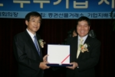이영탁 증권선물거래소 이사장(왼쪽)으로 부터 5년 연속 기업지배구조 최우수 기업상을 수항하는 KT 서정수 전무(오른쪽).