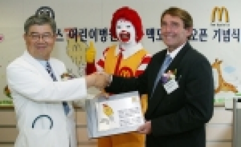 29일 한국 맥도날드의 지원으로 건립된 세브란스 어린이병원 학교 오픈을 기념해 김덕희 세브란스 어린이병원장이 한국맥도날드 레이 프롤리 사장에게 현판을 전달받고 있다.