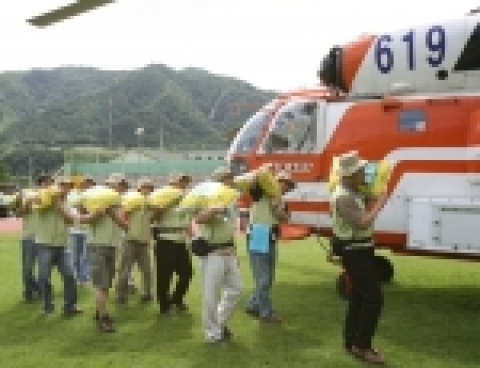 하나은행 수해복구봉사단 직원들이 강원도 덕적리 수해주민들에게 전달할 쌀을 운반하고 있는 모습