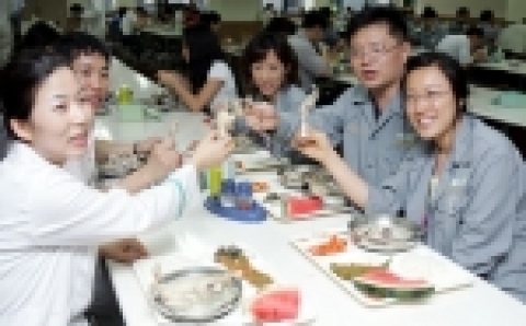 현대중공업이 여름철 보양특식으로 점심시간에 선보인 영계백숙을 임직원들이 맛있게 먹고 있다.