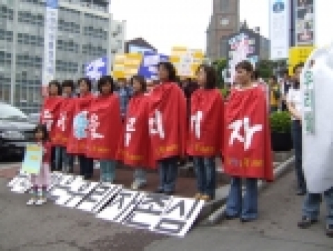 쌀포대를 상징하는 빨간 망또를 두른 한국생협연합회 소비자들이 수입쌀의 유통공개를 촉구하고 있다.