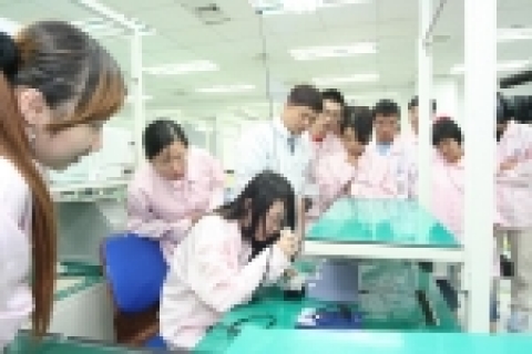 팬택계열 생산팀 박성욱 기좌의 안내로 중국 한국학 장학생들이 휴대폰 생산 실습을 하고 있는 모습.
