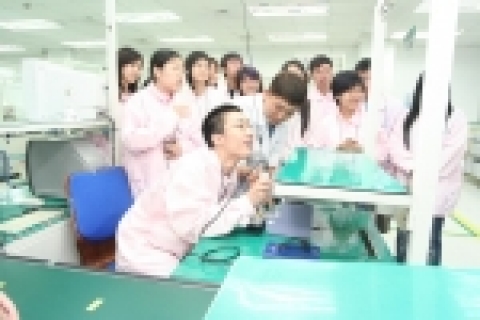 팬택계열 생산팀 박성욱 기좌의 안내로 중국 한국학 장학생들이 휴대폰 생산 실습을 하고 있는 모습.
