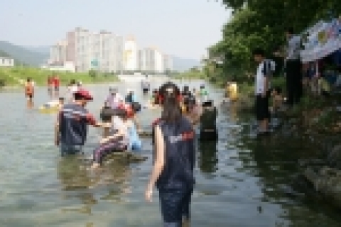 경남은행 봉사단이 희망이 자라는 열린학교에서 봉사 도우미로 아이들과 물놀이를 하고 있다.