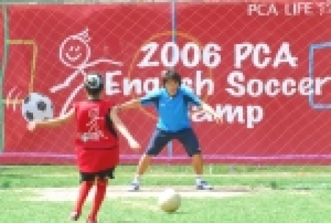 PCA생명빌 라일 대표와 김태영 코치가 SOS 어린이 마을 어린이들과 함께 축구 훈련을 진행하고 있는 모습.