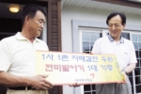 아시아나항공 강주안사장(우측)이 첫 농촌봉사활동을 기념하며 현미발아기 증정서를 외삼포2리 신성교 이장에게 전달하고 있다.