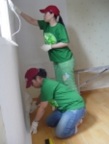 CJ인터넷 사우들이 ‘사랑클릭(Love Click)’이라는 사내봉사동호회 명칭을 딴 단체티셔츠를 맞춰 입고 도배작업을 하고 있다