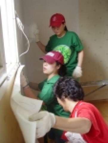 CJ인터넷 사우들이 ‘사랑클릭(Love Click)’이라는 사내봉사동호회 명칭을 딴 단체티셔츠를 맞춰 입고 도배작업을 하고 있다