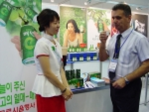 ‘2006 국제광산업 전시회’가 열리고 있는 김대중컨벤션센터 1층 전시장을 찾은 방문객이 매원을 마시고 있는 모습. 
