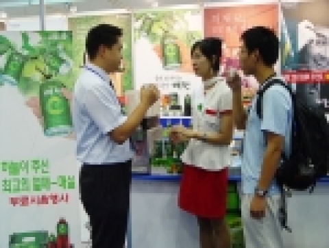 ‘2006 국제광산업 전시회’가 열리고 있는 김대중컨벤션센터 1층 전시장을 찾은 방문객이 매원을 마시고 있는 모습. 