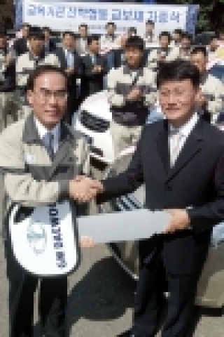 GM DAEWOO A/S 본부 정종욱 상무가 인평 자동차 정보고등학교 이영배 교장에게 실습용 차량 키를 전달하고 있다. GM DAEWOO는 12일 부천 정비연수원에서 토스카 13대