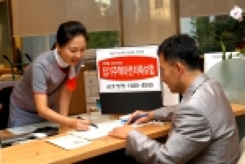 고객창구를 찾은 고객에게 여직원이 상품 설명하는 장면