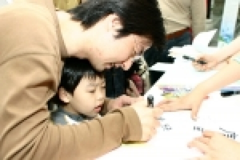 어린 자녀와 함께 가족건강을 위한 소지를 쓰는 아버지