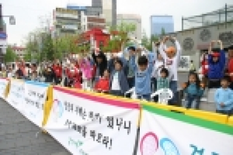건강축제를 관람하며 동작을 따라해보는 어린이와 시민
