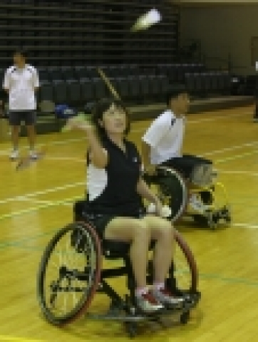 삼성전기 길영아 코치(좌측)가 휠체어를 타고 셔틀콕을 스매싱 하고 있다