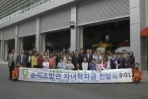 서울 용산소방서에서 S-Oil 김동철 부사장(사진 가운데)과 소방방재청 황정연 차장(사진 가운데)이 순직소방관 및 장애로 인한 퇴직소방관 자녀들에게 학자금을 전달한 후 그 가족들과