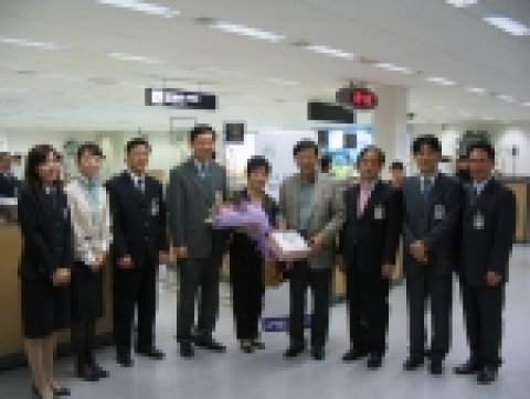 출입국브랜드 선포후 김해공항으로 20만명째 입국하는 안광수씨에 대한 화환, 기념품 전달장면