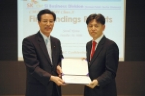SK C&C 공공사업부문장 주정수 전무(왼쪽)가 CMMI 선임 심사원인 장택상 TQMS 대표로부터 CMMI레벨5 인증서를 받고 있다.
