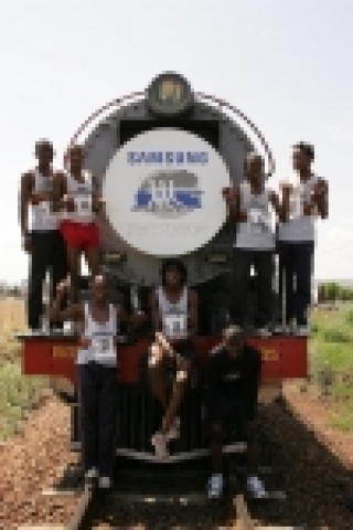 증기기관차를 7초 차이로 누르고 우승한 팀이 포즈를 취하고 있다.