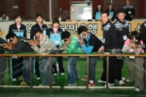 KB사격팀 소속 선수들이 아이들에게 10m 공기소총을 지도하는 모습