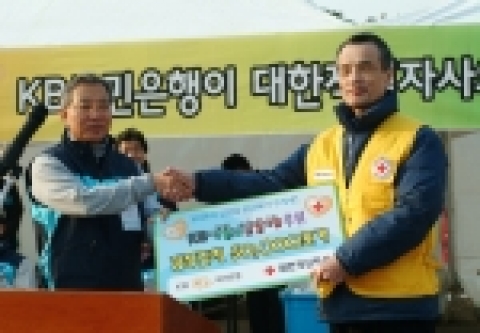 KB국민은행의 강정원 은행장(왼쪽)과 대한적십자사 장석준(오른쪽) 사무총장이 18일 서울 여의도 공원에서 직원들이 자발적으로 모금한 재원으로 국내 최대 규모의 