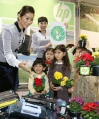 다쓴 프린트 카트리지를 재활용한 플라스틱으로 만든 꽃 화분을 선물로 받은 아이들이 한국HP의 환경프로그램에 대한 설명을 듣고 있다. 이날 친환경상품진흥원으로 부터 친환경인증마크를 