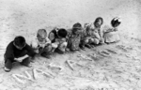 UNICEF/HQ46-0033/Mihanoff 1946년 이집트. UNRRA는 독일군으로부터 유고슬라비아 어린이들을 보호하기 위해 이 곳에 난민캠프를 세웠다. 난민캠프에서 지내는 한 무리의 어린이들이 모래 위에 세르보크로아티아로 ‘우리 학교’라는 글자를 쓰고 고향이 그리운 듯 들여다 보고 있다.