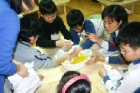 참가자들이 세숫대야에 담긴 청량음료를 천에 물들이고 있다.