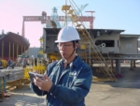 현대중공업 직원이 현장에서 PDA로 자재 입고를 실시간 확인하며, 동시에 사내통신망을 이용, 전화 통화를 하고 있다.