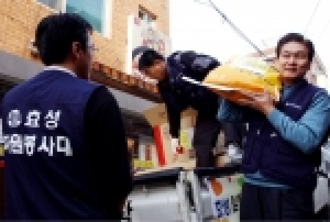 효성 이상운 사장(사진 오른쪽)이 마포구 염리동 소재의 독거노인 세대에 쌀을 배달하기 위해 트럭에서 쌀을 드는 장면