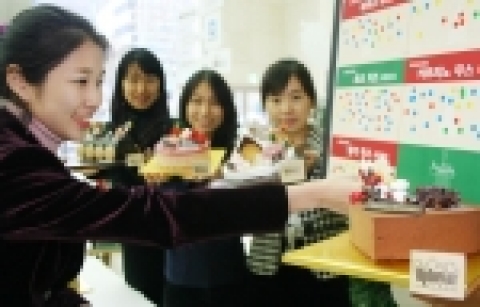 업타운카페 케이크제작에 아이디어를 제공한 고객들이 자신들의 아이디어로 만든 케이크를 들고 환하게 웃고 있다.