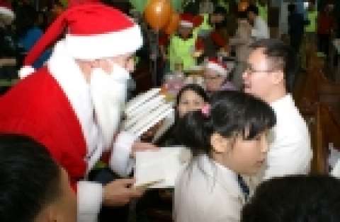 외환은행 나눔재단 로버트 팰런(왼쪽) 이사장이 홀트아동복지회 복지타운을 방문해 산타 복장으로 장애우들에게 선물을 나눠주고 있다. 이날 행사에 참여한 나눔재단의 사랑도우미 회원 50