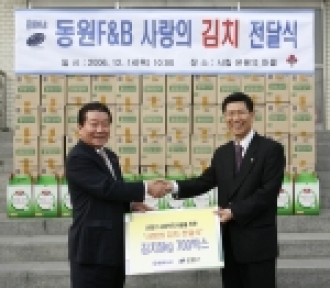 김해관 동원F&B 사장(오른쪽)이 14일 시립 '은평의 마을'에서 노재동 은평구청장에게 양반김치 3.5t을 기증하고 있다. 이 김치는 은평구 내 45개 사회복지시